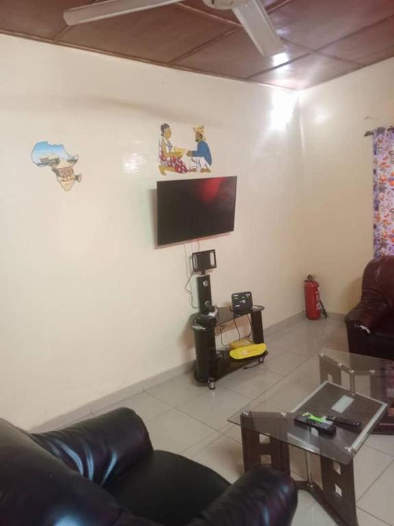 een woonkamer met een bank en een flatscreen-tv bij YILIMDE APPARTEMENTS in Ouagadougou