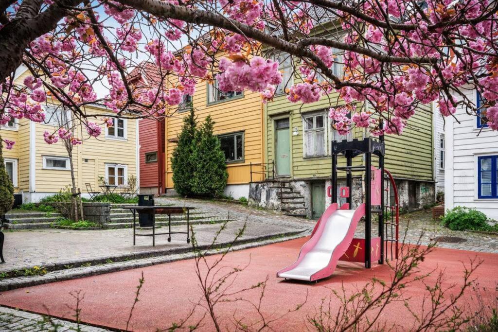 a playground with a slide in front of a house at Dinbnb Apartments I Romantic Surroundings in The City Center in Bergen