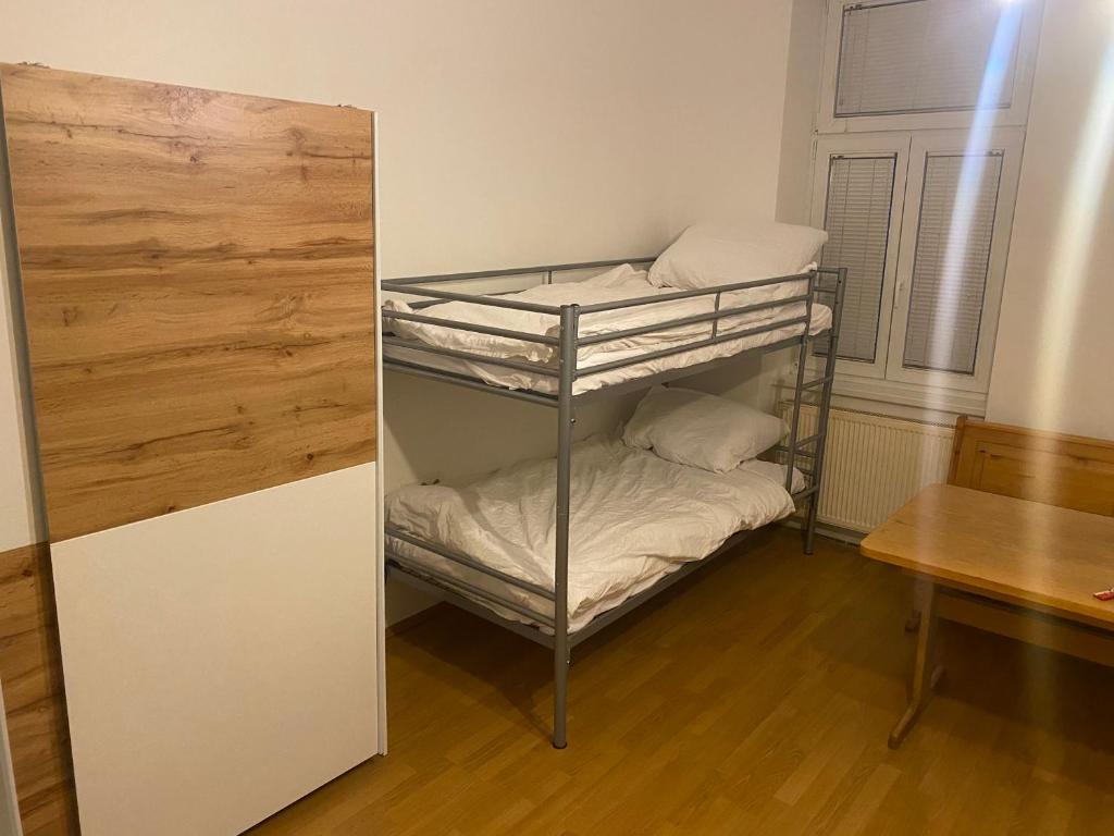 Cette chambre dispose de lits superposés avec 2 lits superposés et une table. dans l'établissement Cheap Apartment for 8 people. Vienna. 10th district, à Vienne