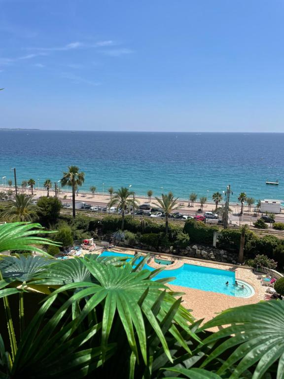 un resort con piscina e oceano sullo sfondo di BY NEPTUNE - la Palme Riviera Beach and Pool view a Cannes