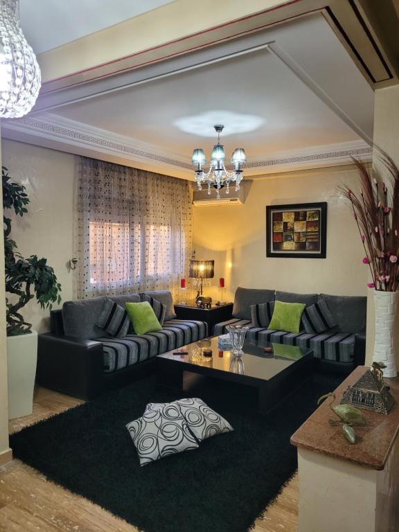 a living room with couches and a table at Cosy Dounia avec parking privatif in Casablanca
