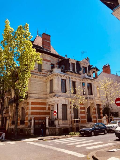 un vieux bâtiment au coin d'une rue dans l'établissement La Maison Rouge - Maison Familiale & Proche centre, à Vichy