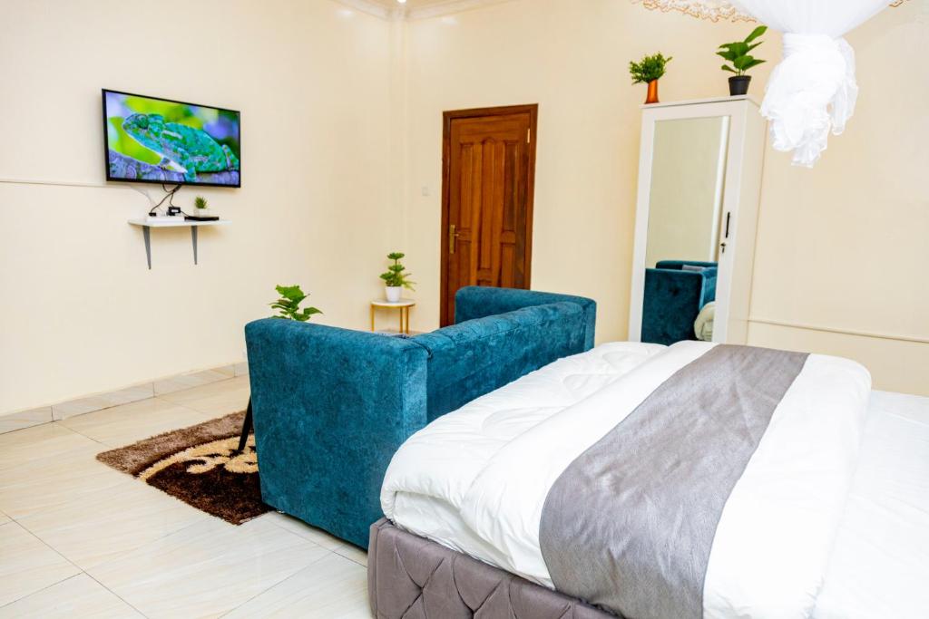 1 dormitorio con 1 cama grande y 1 sofá azul en Luxury Studio @ Twiga House en Kigali