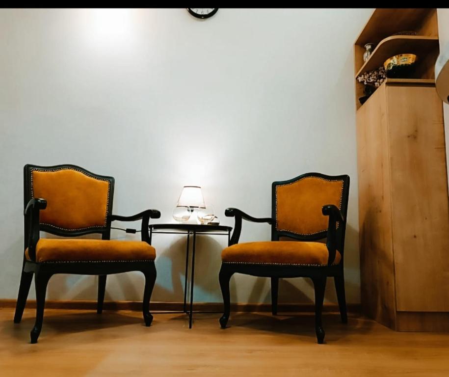 dos sillas sentadas junto a una mesa con una lámpara en New apartment BARNABA close to Holiday Inn en Tiflis