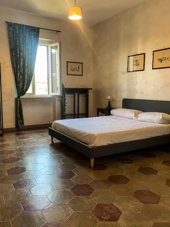 una camera da letto con un grande letto e una finestra di Il Nido apartment Roma, Attico ostiense a Roma