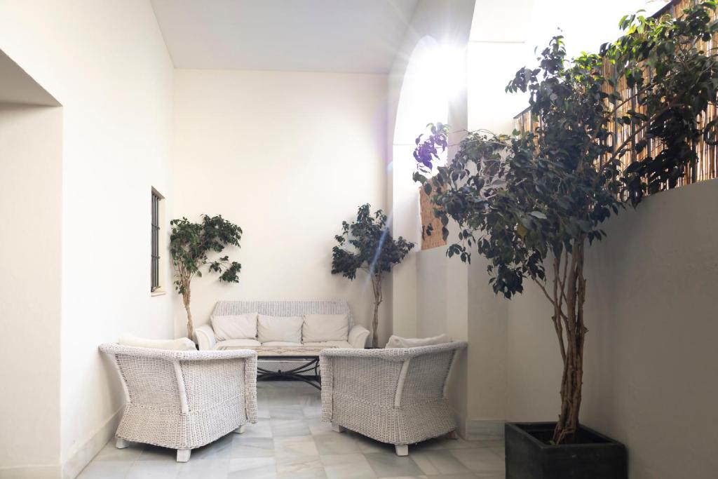 a living room with a couch and chairs and trees at Palacio de Luja in El Puerto de Santa María