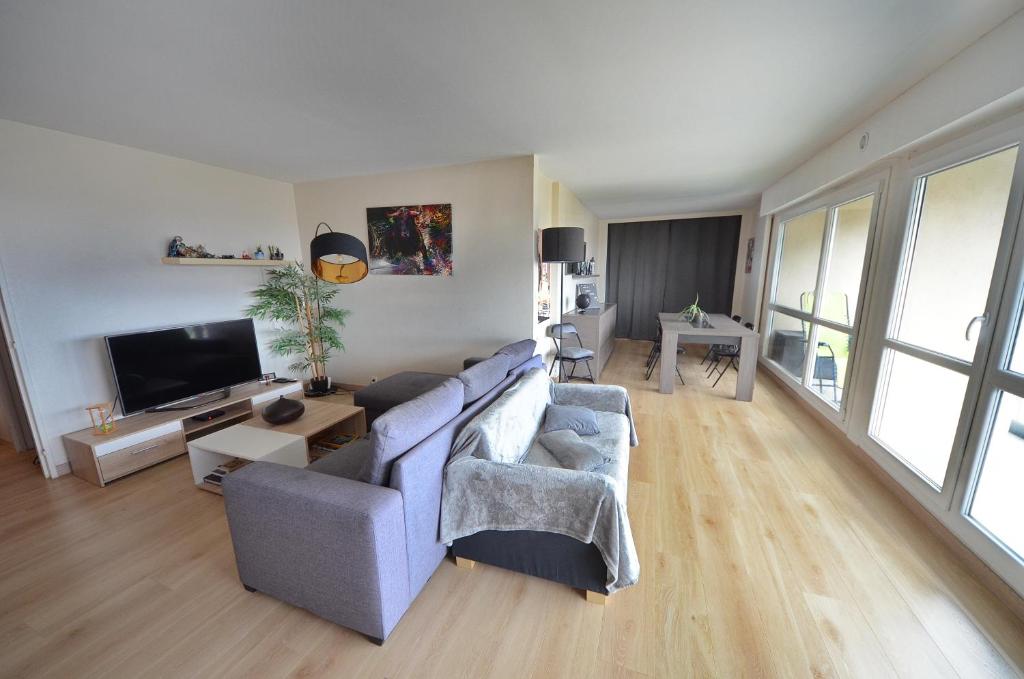 een woonkamer met 2 banken en een tv bij Elancourt Panorama & Élégance proche sites JO 2024 in Élancourt
