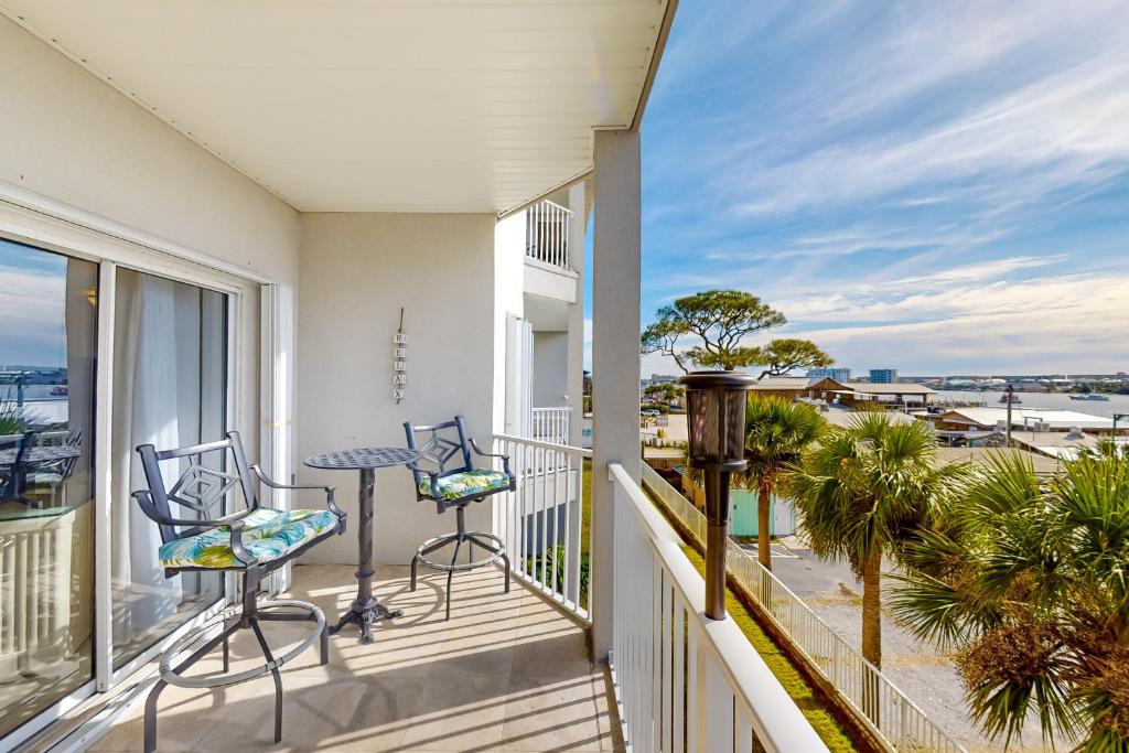 einen Balkon mit Stühlen, einem Tisch und Meerblick in der Unterkunft Barataria 204 in Destin
