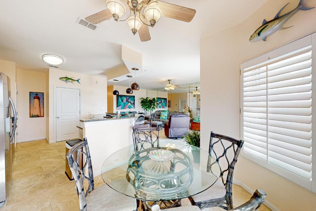 ein Esszimmer und eine Küche mit einem Glastisch und Stühlen in der Unterkunft Barataria 204 in Destin