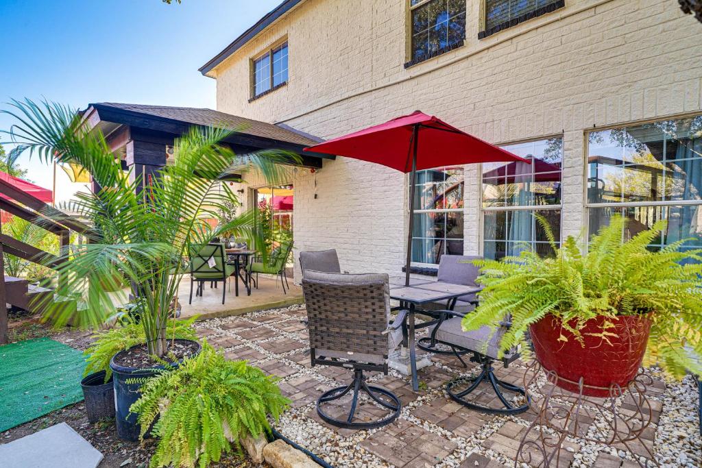 a patio with a table and a red umbrella at San Antonio House with Pool about 9 Mi to Lackland AFB! in San Antonio