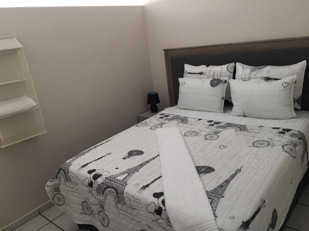 a bedroom with a bed with a black and white comforter at 15 uvongo square holiday home in Margate