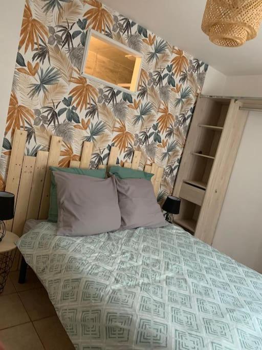 une chambre avec un lit avec un papier peint fleuri dans l'établissement Appartement avec terrasse 2, à Gien