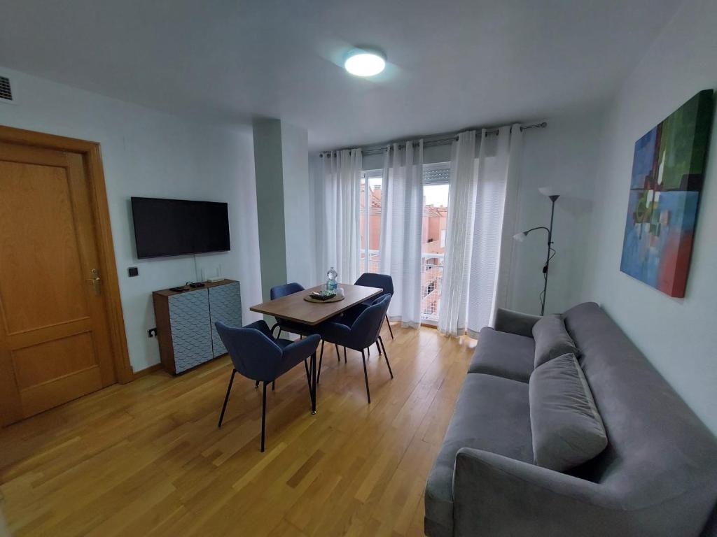 ein Wohnzimmer mit einem Sofa und einem Tisch in der Unterkunft APARTAMENTO PLAZA DEL AYUNTAMIENTO con PARKING in Linares
