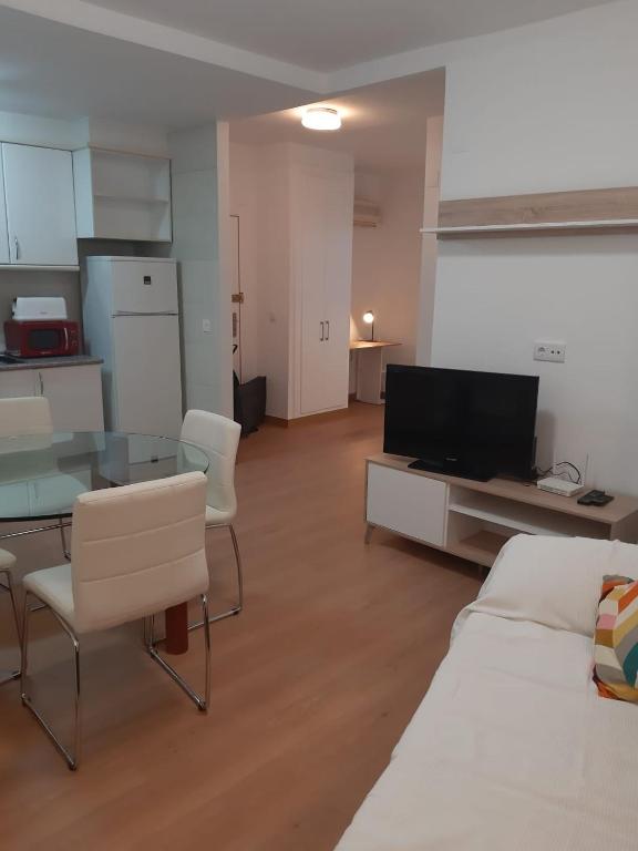 sala de estar con mesa, sofá y TV en Las Flores en Murcia