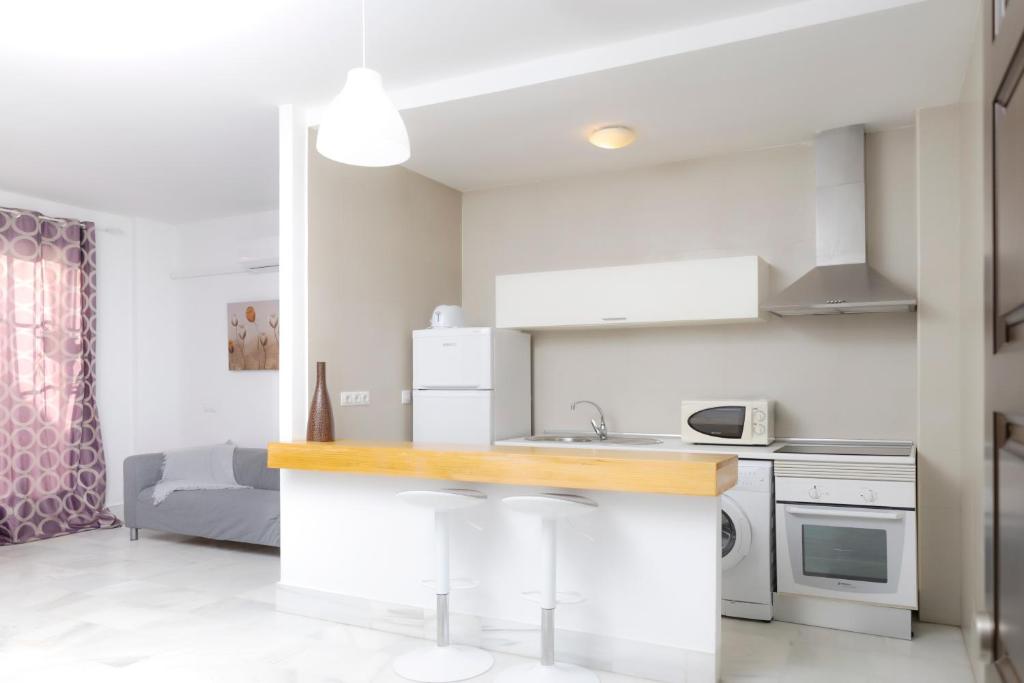 a white kitchen with a counter and a sink at Palacio de Luja in El Puerto de Santa María