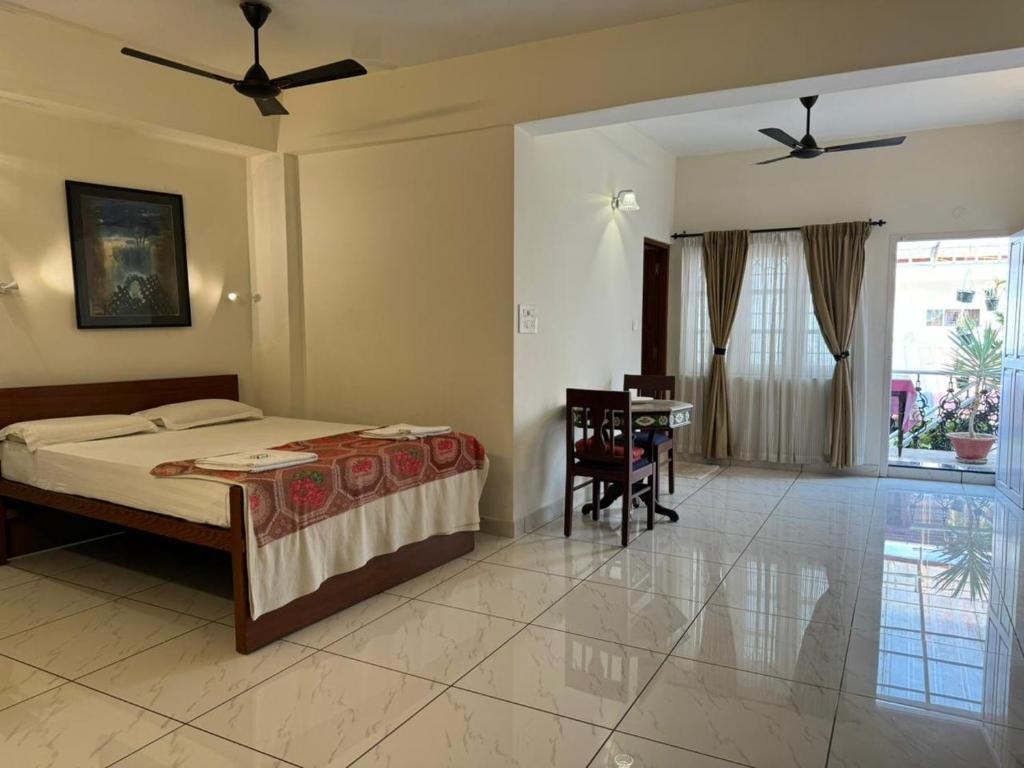 a bedroom with a bed and a table in it at Aambal Residency in Cochin