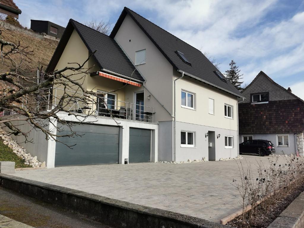 een groot wit huis met een grote garage bij Alpenblick Monteurzimmer und Ferienwohnung 