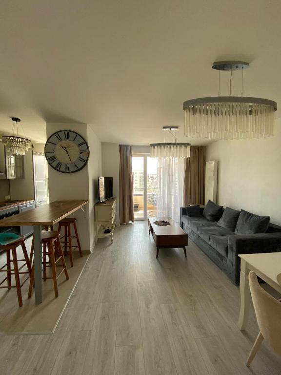 een woonkamer met een bank, een tafel en een klok bij Royal Apartament in Braşov