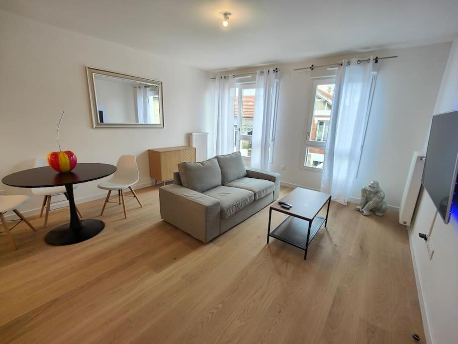a living room with a couch and a table at Le clos d'Asnières in Asnières-sur-Seine