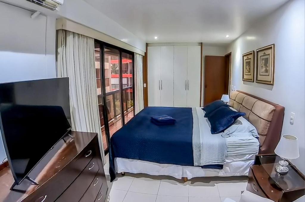 1 dormitorio con 1 cama y TV de pantalla plana en Flat Vieira Souto Vista Mar, en Río de Janeiro