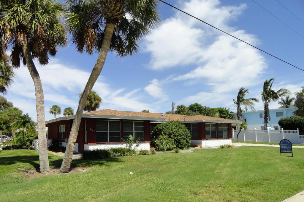 een huis met palmbomen ervoor bij Bollinger Duplex Both Sides in Holmes Beach