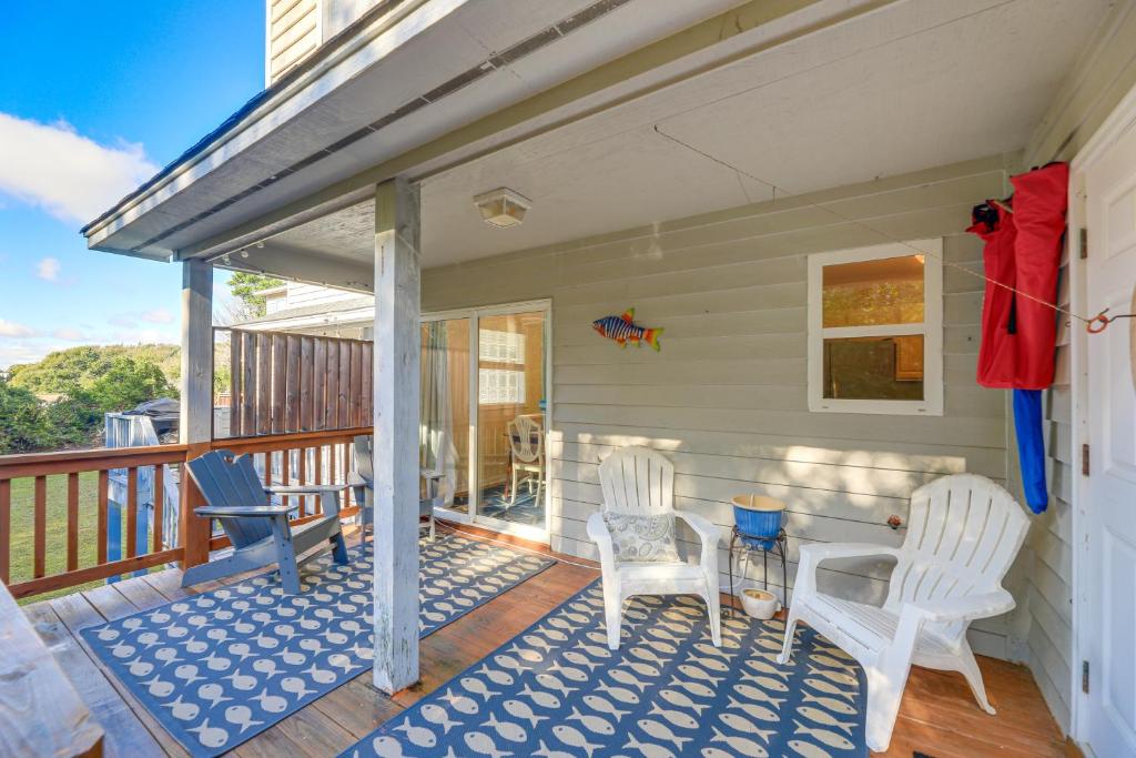 a porch with two white chairs and a table at Well-Equipped Emerald Isle Townhome Pets Welcome! in Emerald Isle
