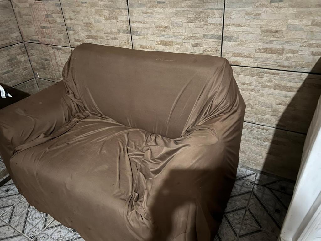 a brown leather chair sitting in a room at Condomínio luiza in Rio Branco