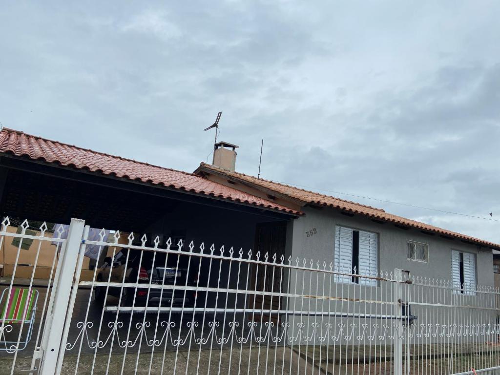 una casa blanca con una valla delante en Pousada da Maria, en São Gabriel