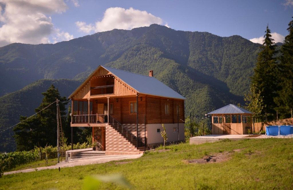 una casa en una colina con montañas en el fondo en Wonder Inn 