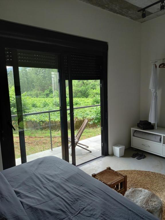 a bedroom with a bed and a sliding glass door at Pousada IMcasa 430 in Bento Gonçalves