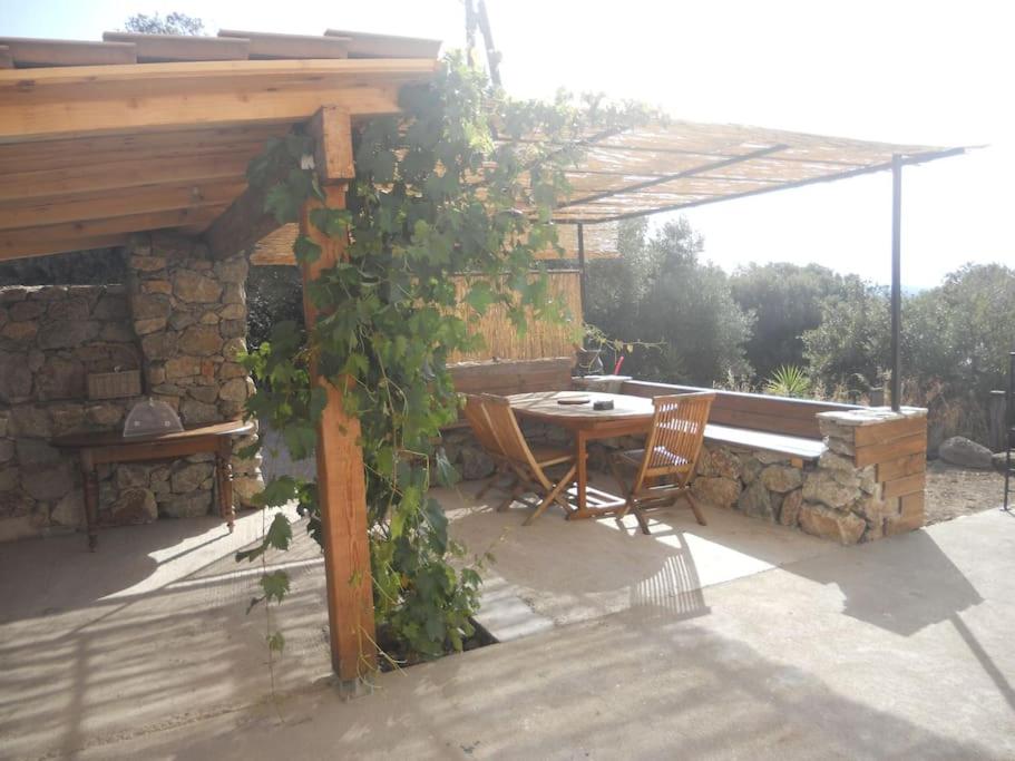 un patio avec une table et des chaises sous une pergola dans l'établissement SEJOUR DETENTE BALAGNE ENTRE MER ET MONTAGNE, à Urtaca