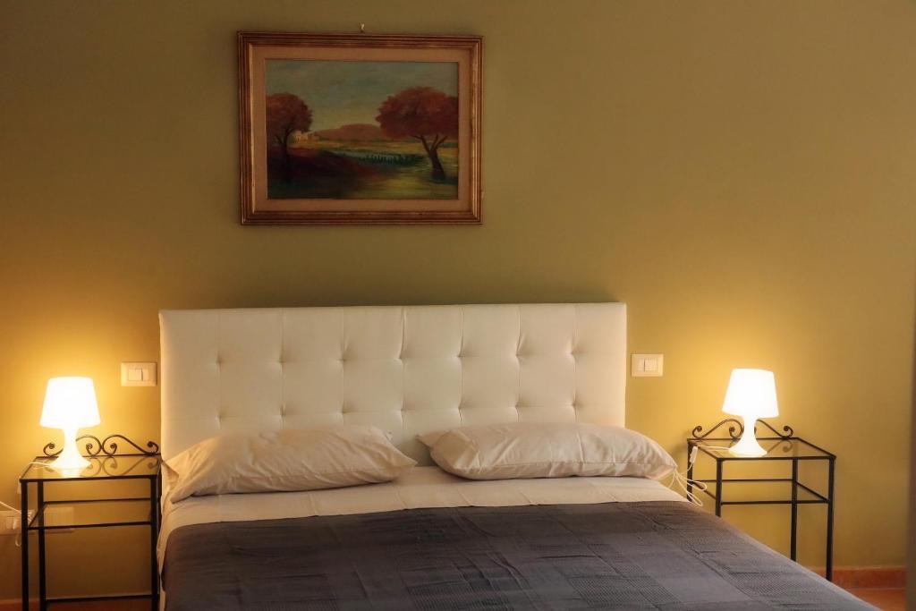 Piano的住宿－LadimoradiLu'，卧室配有带两盏灯的白色床