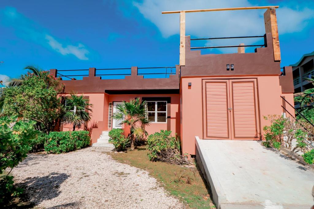 a house with a red garage in front of it at Villa 12 at Mara Laguna - Gold Standard Certified in San Pedro