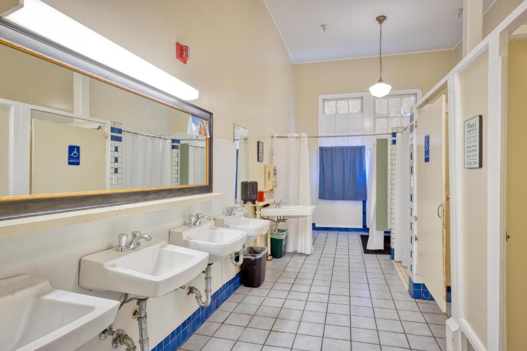 a bathroom with three sinks and two mirrors at HI San Francisco Fisherman's Wharf Hostel in San Francisco