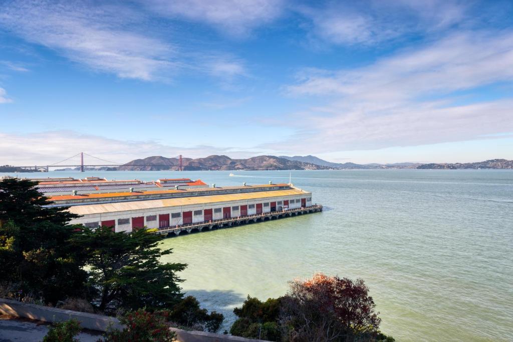 a building on the water with a bridge in the background at HI San Francisco Fisherman's Wharf Hostel in San Francisco
