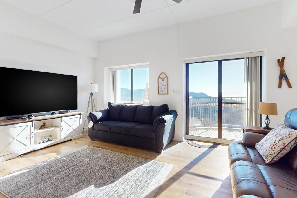 a living room with a couch and a flat screen tv at Citadel 3728 in Sugar Mountain