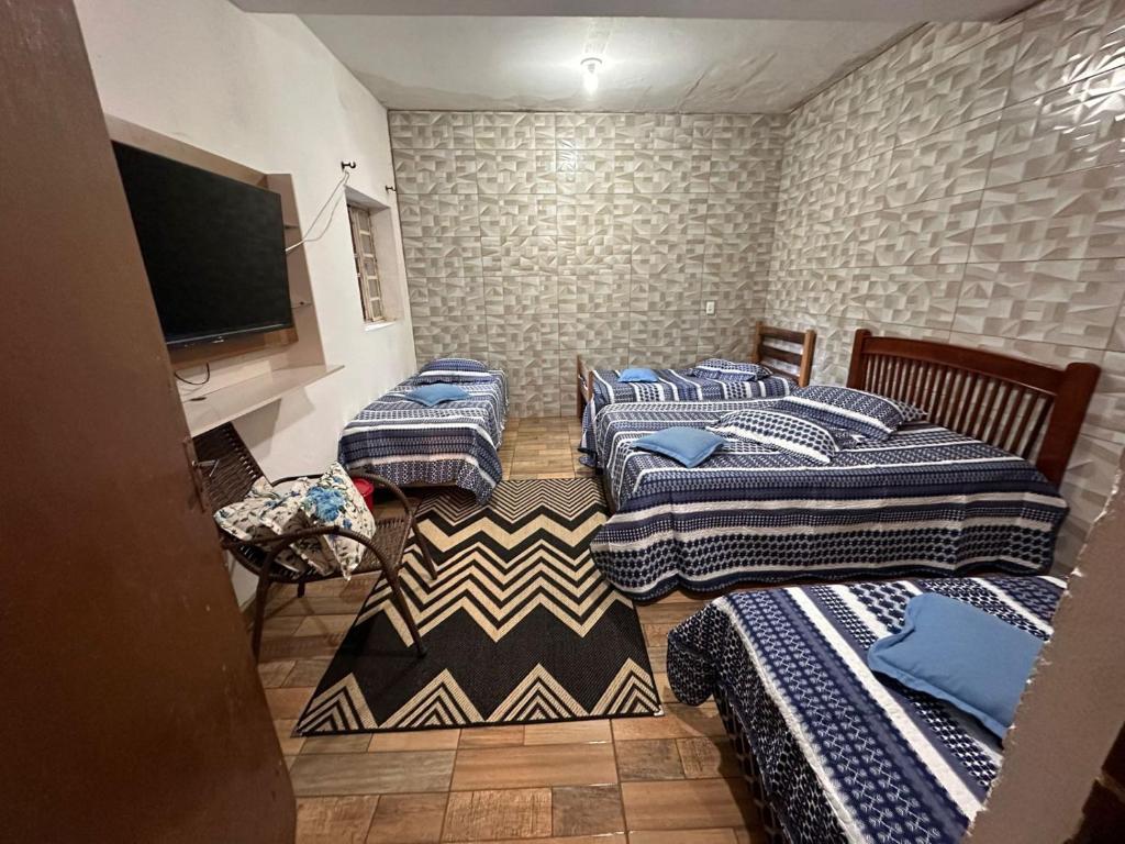 a room with four beds and a flat screen tv at A CASA DE IRENE I in Aparecida