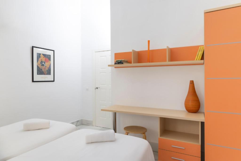 a room with two beds and a desk and a table at Palacio de Luja in El Puerto de Santa María