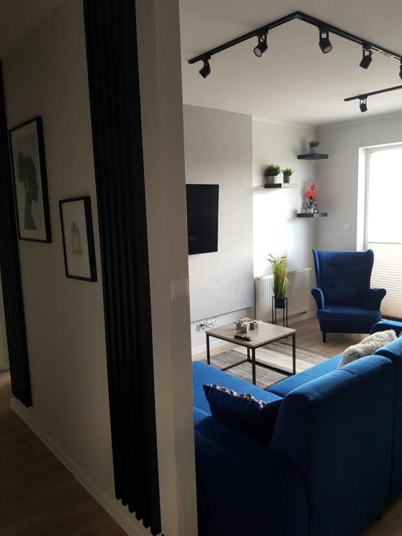 a living room with a blue couch and a table at Apartamenty Limanowskiego in Bartoszyce