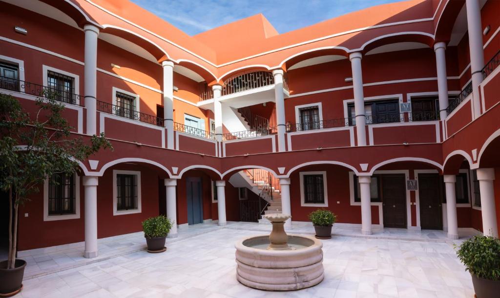 an empty courtyard of a building with a fountain at Palacio de Luja in El Puerto de Santa María