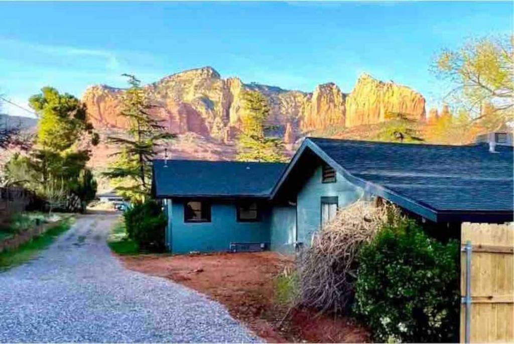 a blue house with a mountain in the background at Heart of Uptown retreat estate with views and hot tubs in Sedona