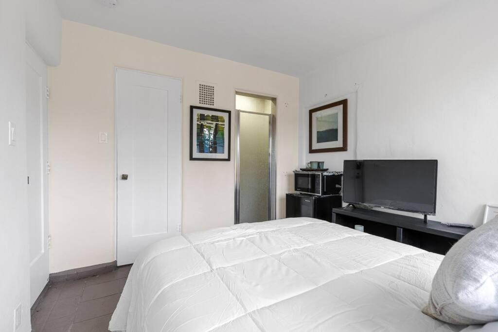1 dormitorio blanco con 1 cama y TV de pantalla plana en Mack - Six Flags, Universal, LAX, private studio, en Santa Clarita