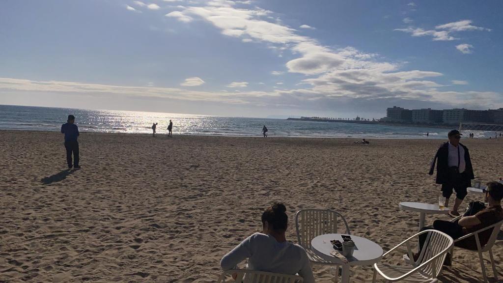 un grupo de personas sentadas en sillas en la playa en PLAYA POSTIGUET, en Alicante