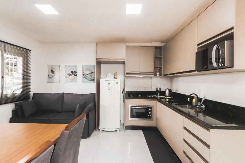 cocina con sofá y mesa en una habitación en Apartamento Completo e Confortável em Bento 02, en Bento Gonçalves