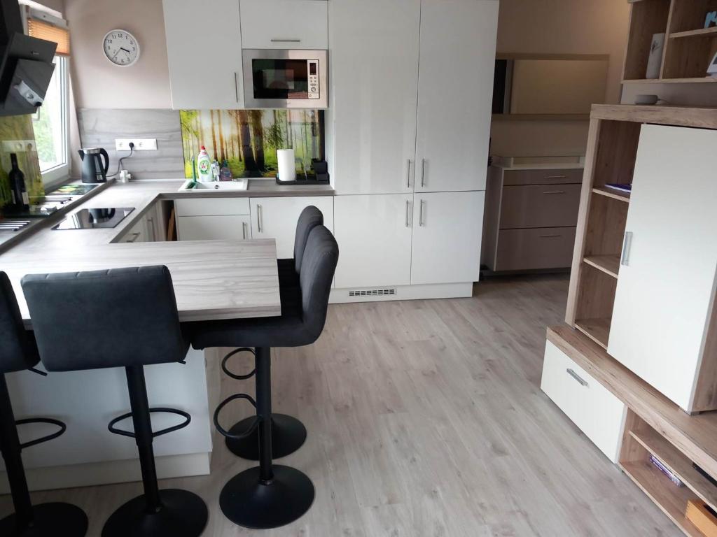 a kitchen with a table and two bar stools at Prime Apartment Heviz in Hévíz