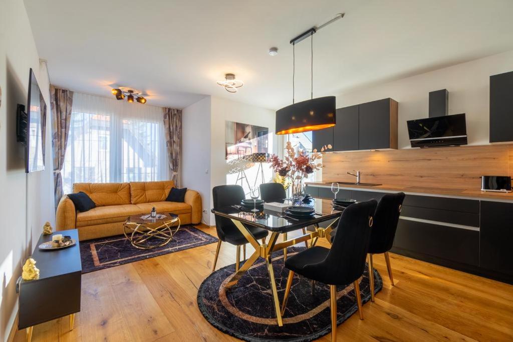 een keuken en een woonkamer met een tafel en stoelen bij Bennett Apartment in Wenen