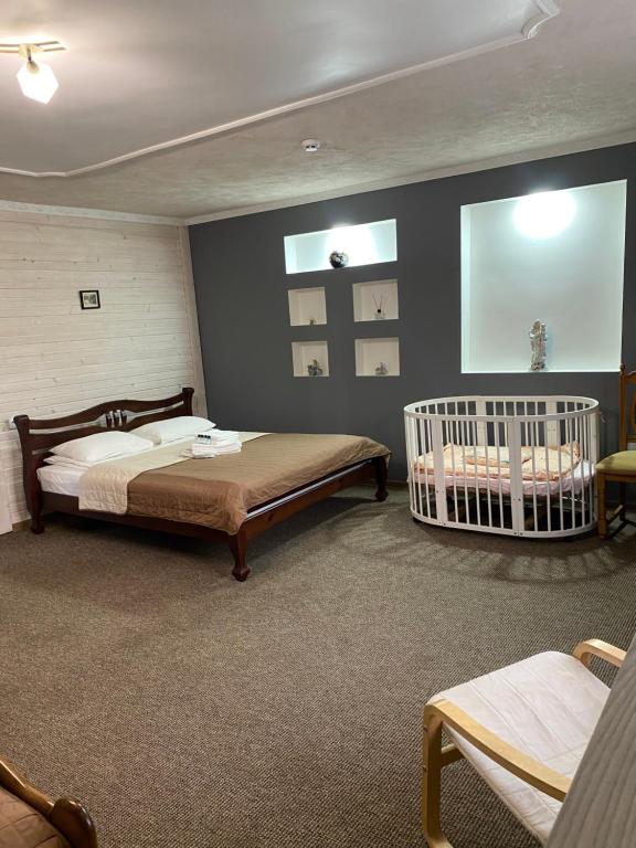 a bedroom with two beds and a crib in it at Guest house Shulc in Mizhhirya