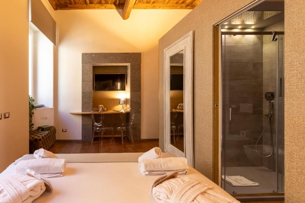 a room with a shower and a bed with towels at Fontana di Trevi Roma Luxury Suite in Rome