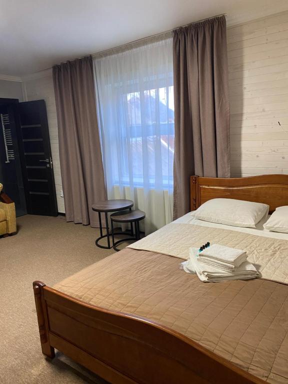 a bedroom with a large bed and a window at Guest house Shulc in Mizhhirya