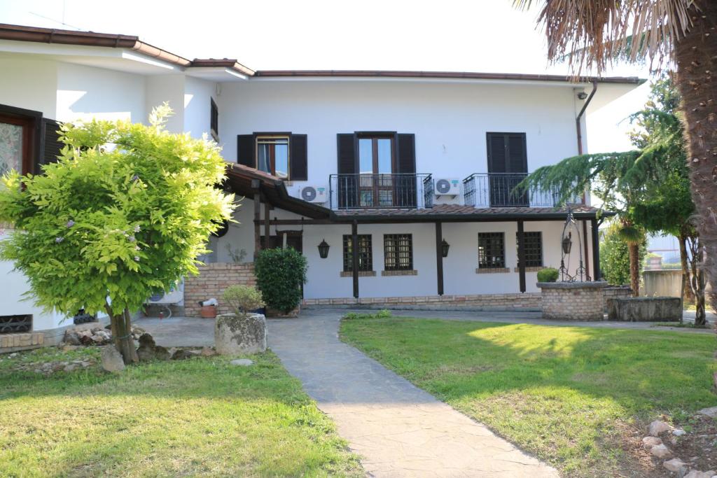 a white house with black windows and a yard at Appartamenti via Calnova in Noventa di Piave